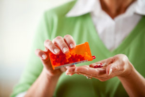 woman pouring pills into her hand